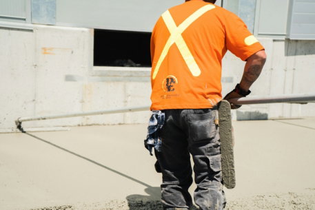 a man in an orange shirt is holding a skateboard