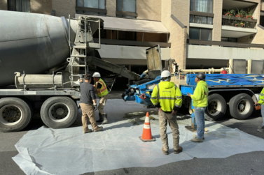 a group of men standing next to a cement truck