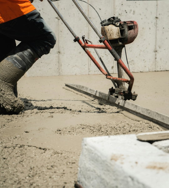 a man using a machine to pour concrete