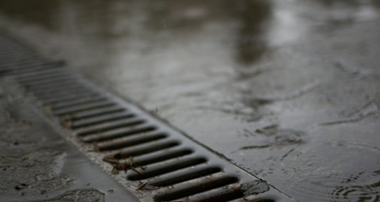 a-metal-drain-on-a-wet-concrete-surface-.jpg A metal drain on a wet concrete surface.