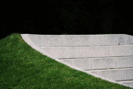green grass field near gray concrete wall