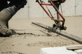 a man using a machine to pour concrete