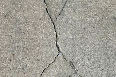 the-crack-in-the-concrete-shows-a-crack-in-the-road.jpg the crack in the concrete shows a crack in the road