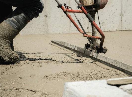 a man using a machine to pour concrete